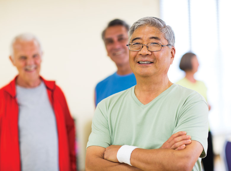 Older adult smiling with arms folded